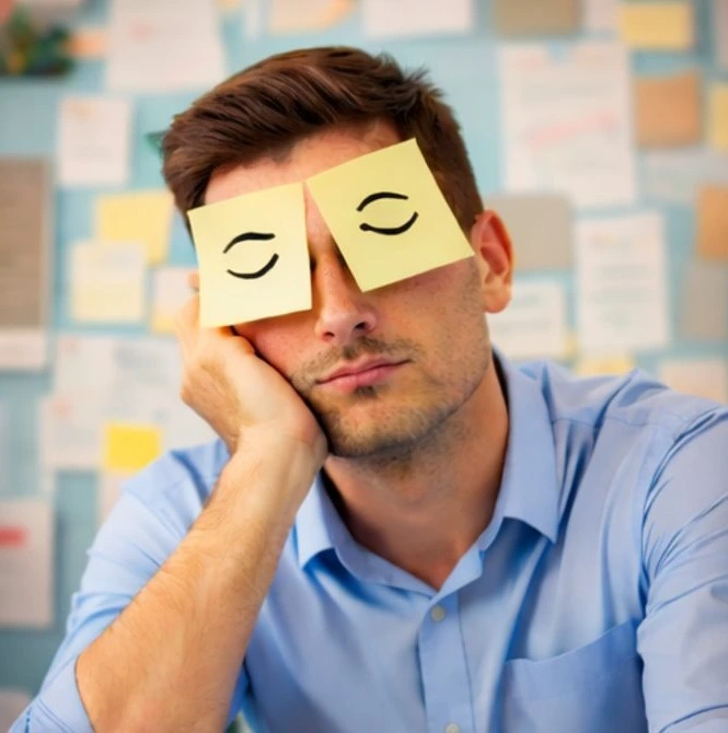 Man die post-its op zijn ogen heeft plakken om te verbergen dat hij slaapt. 