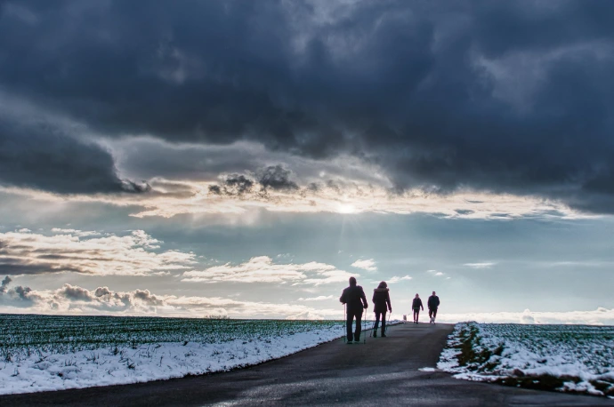 Mensen aan zee met een donkere wolk boven zich