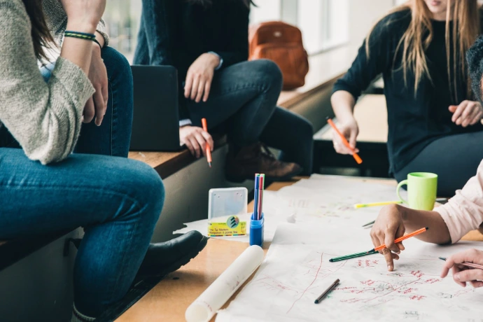 Groep mensen die samenwerken rond een plan 