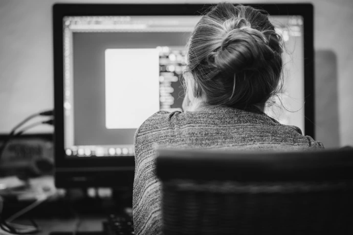 Donkere foto van iemand die aan de computer aan het werken is 